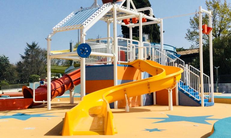 Water park with yellow slide and water bucket.