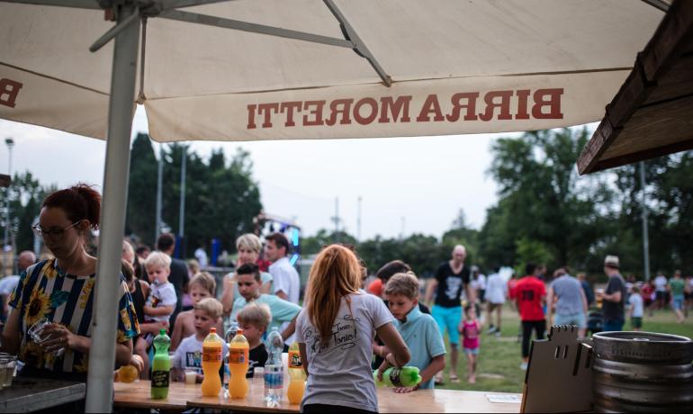 Outdoor-Party mit Kindern und Getränkestand.