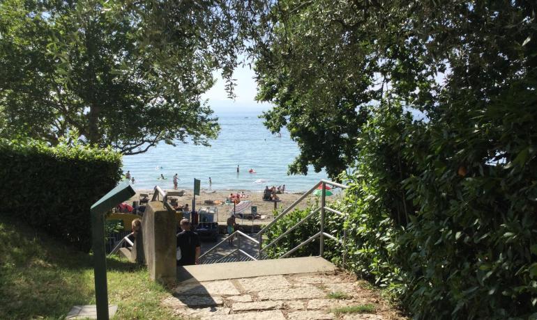 Weg zum Strand mit Blick auf das Meer und Schwimmer.