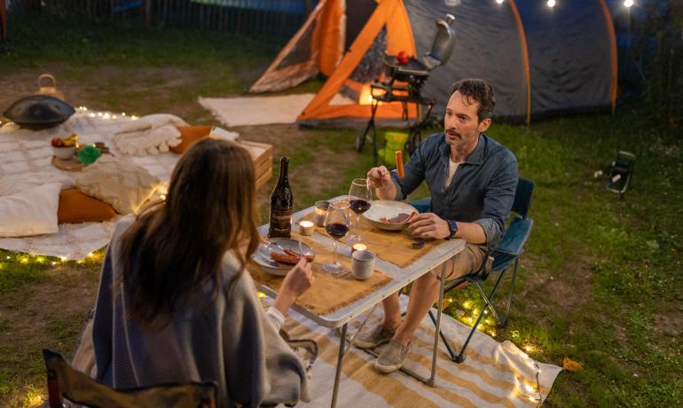 Romantisches Camping-Dinner mit Wein und Kerzen.