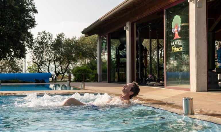 Ontspannen man in zwembad bij fitnesscentrum.