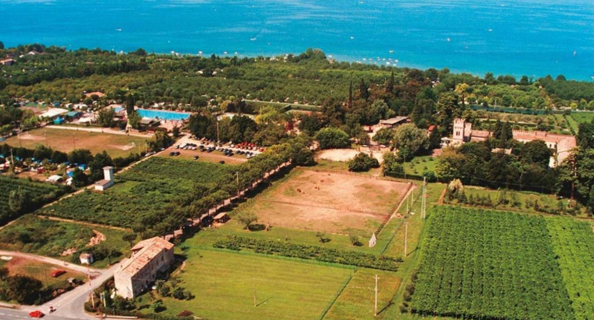 Luchtfoto van een landgoed met velden en een zwembad bij de zee.