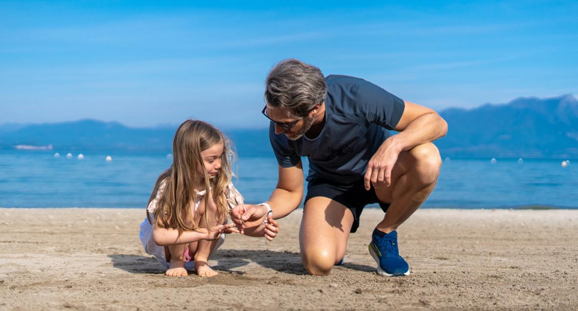 Vater und Tochter spielen fröhlich am Strand und teilen einen besonderen Moment.