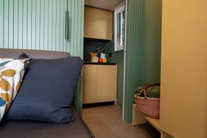 Interno accogliente con colori caldi, divano e cucina moderna.