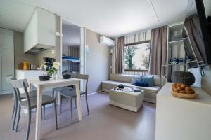 Accogliente soggiorno moderno con cucina, divano e luce naturale.