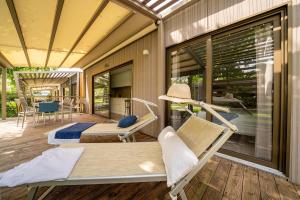Veranda soleggiata con lettini e tavolo, relax estivo all'aperto.