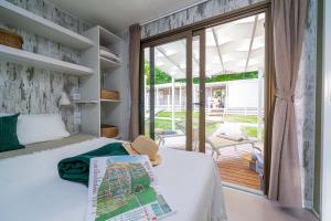 Bright room with garden view, map and hat on bed.