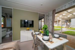 Cozy interior with set table, TV, and view of green veranda.