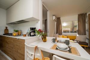 Cucina luminosa e accogliente con tavolo apparecchiato e divano giallo.