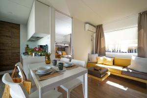 Interno moderno e accogliente con cucina, tavolo e divano luminoso.