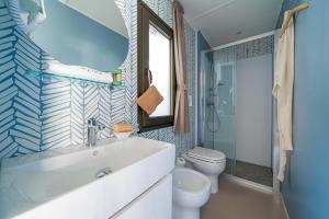 Bagno moderno, luminoso, con doccia e pareti blu decorate.