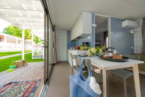 Accogliente cucina moderna, luce solare, verde esterno, atmosfera rilassante.