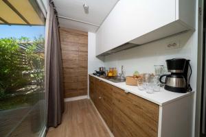 Bright modern kitchen with warm wood, nature outside, and coffee ready.