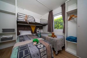 Cozy room with beds, stuffed animals, and natural light.