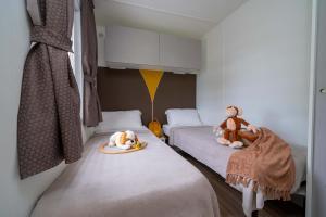 Gezellige kamer met eenpersoonsbedden, knuffels en warme kleuren.
