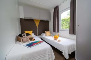 Gezellige kamer met twee bedden, knuffels en kleurrijk speelgoed.
