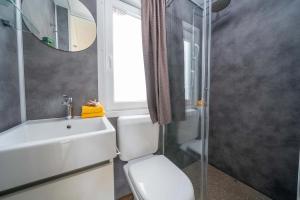Moderne, kleine, lichte badkamer met elegante details en gele handdoeken.