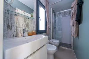 Bagno moderno e luminoso con doccia, lavandino e decorazioni eleganti.