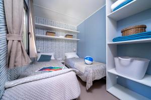 Gemütliches Zimmer mit Einzelbetten, blauer Dekor und entspannter Atmosphäre.
