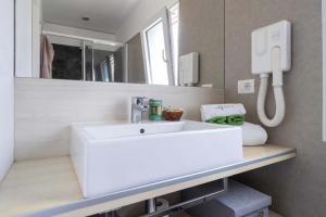Bagno moderno, elegante e ordinato, con lavabo bianco e dettagli minimalisti.