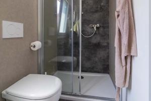 Bagno moderno, doccia elegante e atmosfera pulita e ordinata.