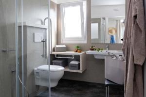 Bright, modern bathroom with glass shower and plants, minimalistic style.