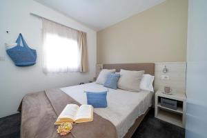 Cozy room with bed, open book, and flowers, serene atmosphere.