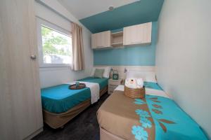 Bright room with single beds, soothing colors, and cozy decorations.