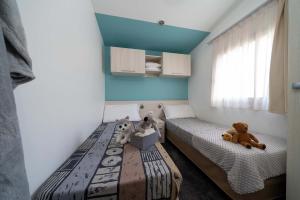Cozy room with single beds and plush toys on colorful blankets.