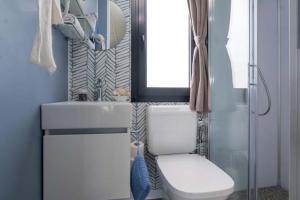 Modern bathroom, cozy, with shower, white sink, and bright window.