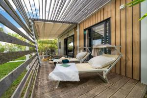 Cozy terrace with loungers, sun, and relaxation amidst nature and comfort.