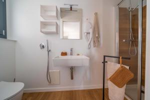 Bagno moderno, minimalista, accogliente, con doccia e lavabo elegante.