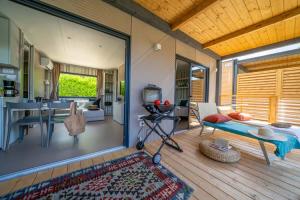 Terrazza accogliente con barbecue, lettino e vista su interni moderni e luminosi.