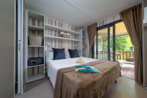 Gezellige kamer met tweepersoonsbed en uitzicht op groene terras.