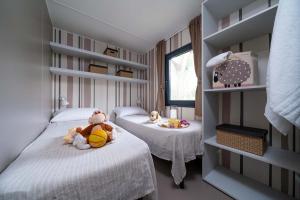 Knusse kamer met eenpersoonsbedden, speelgoed en warme decoraties.