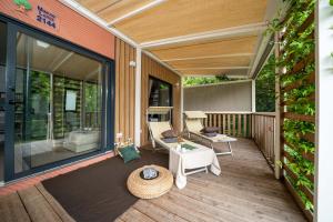 Gezellig terras met ligstoelen, groene planten en een ontspannen sfeer.