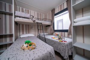 Camera accogliente con letti a castello e giochi colorati, atmosfera calda e familiare.