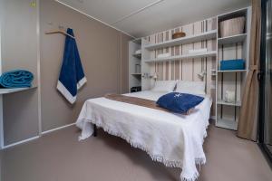 Cozy room with bed, white sheets, and blue decorations.