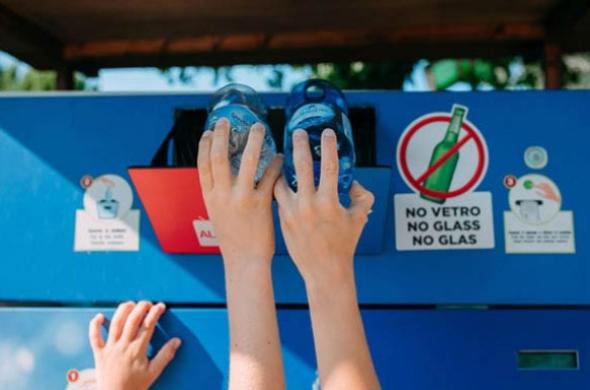 Riciclo di bottiglie di plastica in un contenitore apposito.